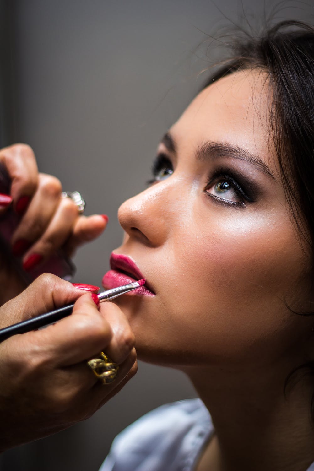 Mujer pintándose los labios de rosa